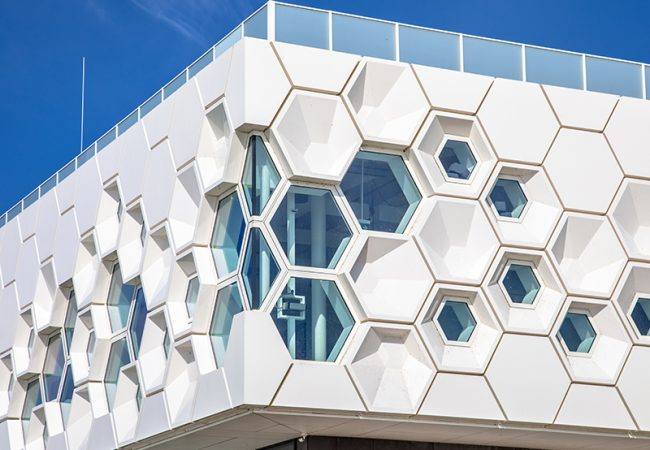 Closeup of modern facade of geometric architecture building in the Netherlands against blue sky.